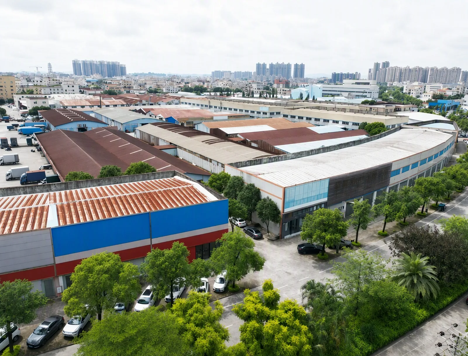 Aerial view of CFKS door manufacturing factory in Zhongshan, China, showing production buildings, warehouses, and tree-lined streets.